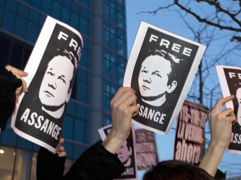 Betogers voor de Britse ambassade in Madrid eisen de vrijlating van Julian Assange.
