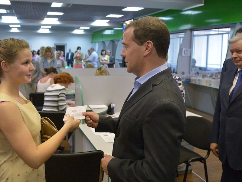 Dmitri Medvedev deelt een Russisch paspoort uit aan een jonge vrouw op de Krim.