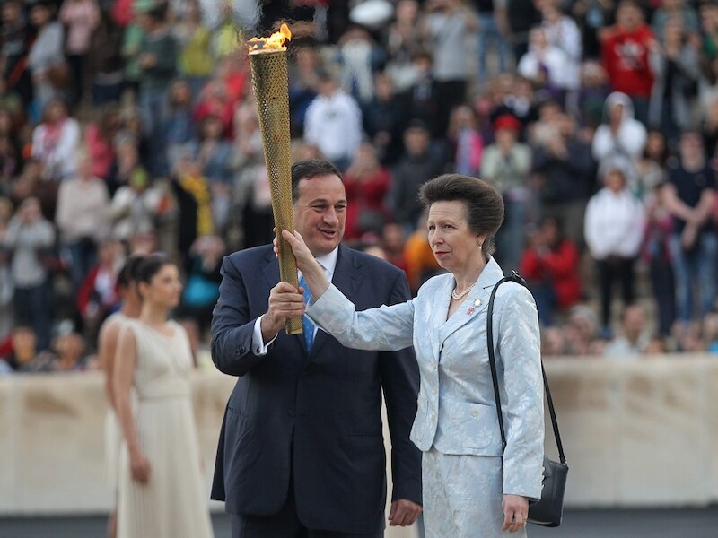 De Olympische Vlam wordt overgedragen door Spyros Capralos aan prinses Anne, dochter van de Britse Queen Elizabeth II