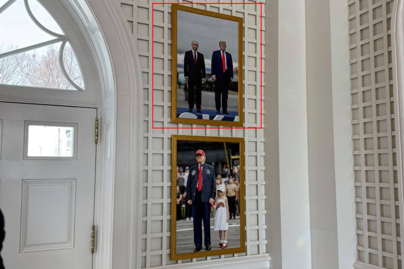 De foto van Poetin en Trump in het Witte Huis. De foto hangt aan een witte muur in een inkomhal, boven een foto van Trump en zijn kleindochter.