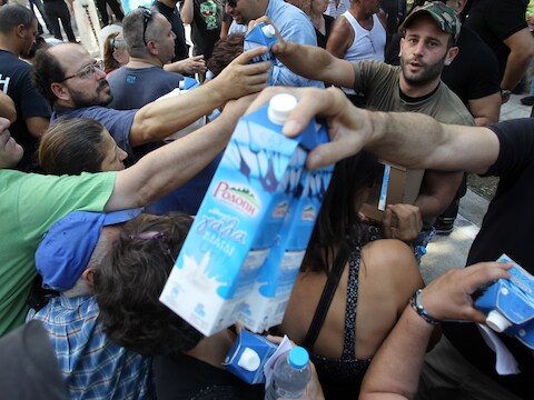 Leden van de Griekse neonazipartij 'Gouden Dageraad' delen melk uit in Athene. De militanten delen enkel voedsel uit aan autochtone Grieken.