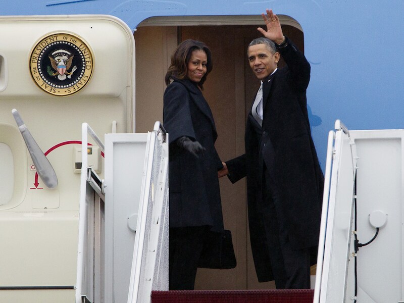 Barack en Michelle Obama stappen aan boord van de Air Force One, op weg naar de herdenking van Nelson Mandela in Zuid-Afrika.