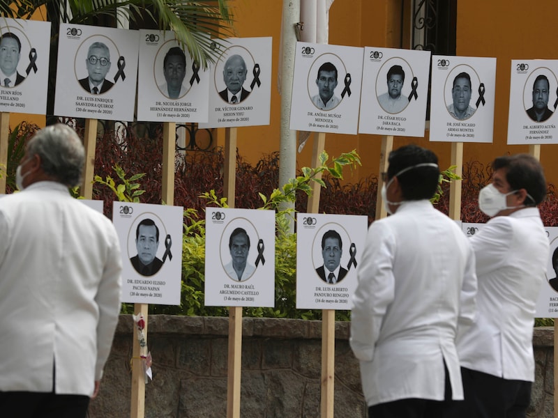 Dokters kijken naar hun aan Covid-19 overleden collega's in Lima.