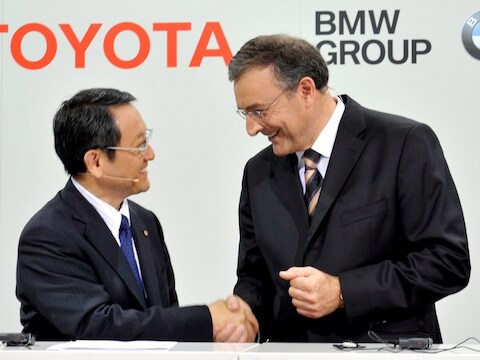 Akio Toyoda, topman van Toyota, schudt BMW-topman Norbert Reithofer (r.) de hand.