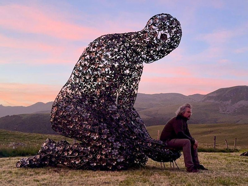 Wilfried De Cock bij zijn monumentale kunstwerk Le Géant du Souffle in de Franse Auvergne. De reus staat op zo’n 1.360 meter hoogte en bestaat uit meer dan 1.600 bloemen van cortenstaal.