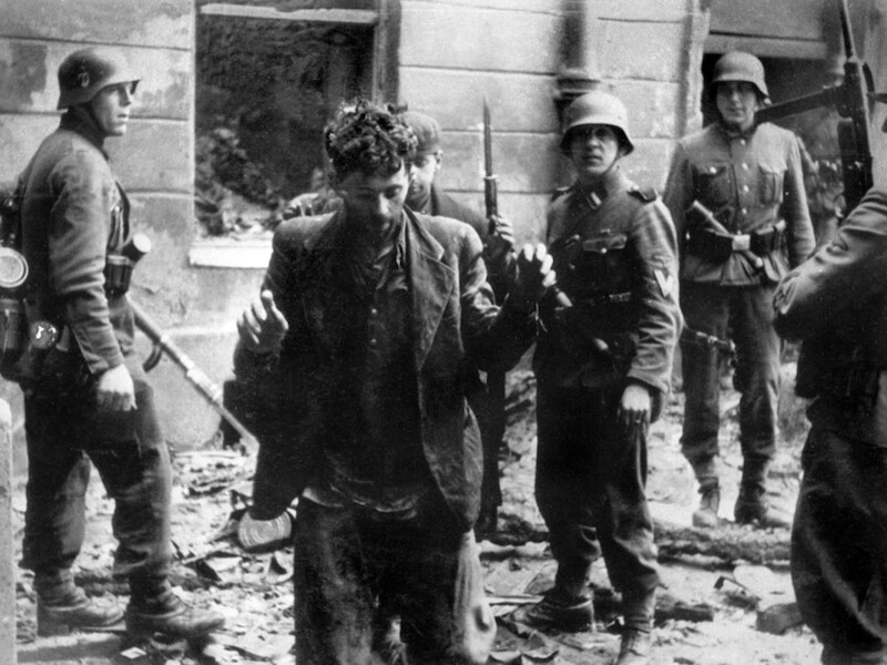 Een Joodse man wordt gearresteerd door Duitse soldaten in een ghetto van Warschau in 1943.