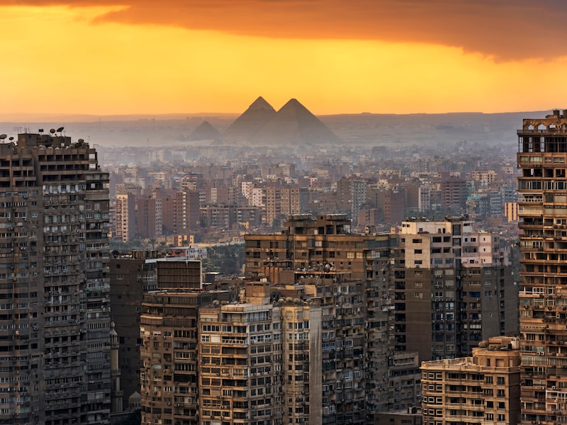 De skyline van Cairo, met de piramides van Giza op de achtergrond.