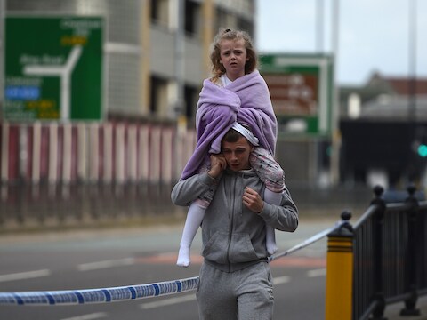 Een man met een jong meisje op zijn schouders in Manchester, een dag na de aanslag op het concert van Ariana Grande.