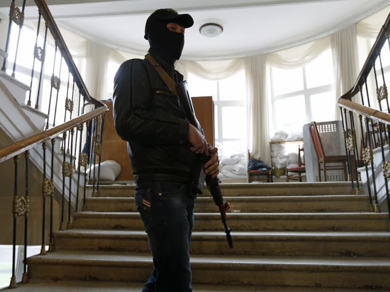 Een pro-Russische betoger houdt de wacht in het veroverde regeringsgebouw in Lugansk.