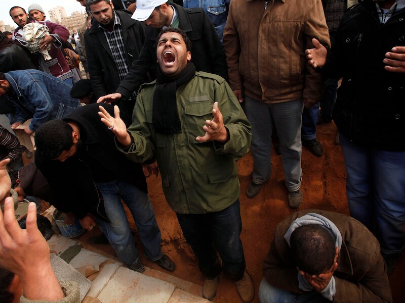 Rouwende rebellen in Ajdabiyah, Libië. Eén van hun strijdmakkers kwam er om het leven.