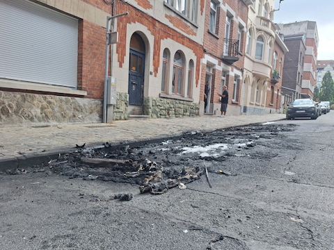 In de straat zijn nog sporen van de uitgebrande wagens te zien.