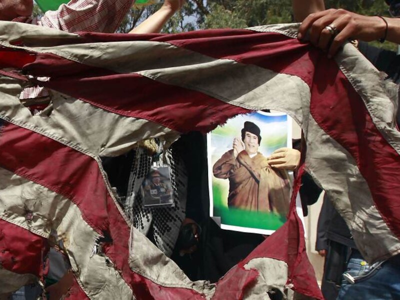 Medestanders van Kadhafi vernielen een Amerikaanse vlag.