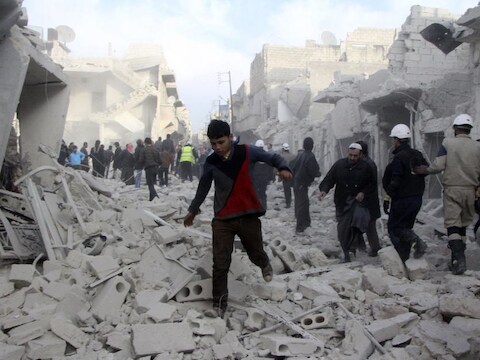 Burgers van Aleppo banen zich een weg door het puin na een bomaanslag van de troepen van president Assad.