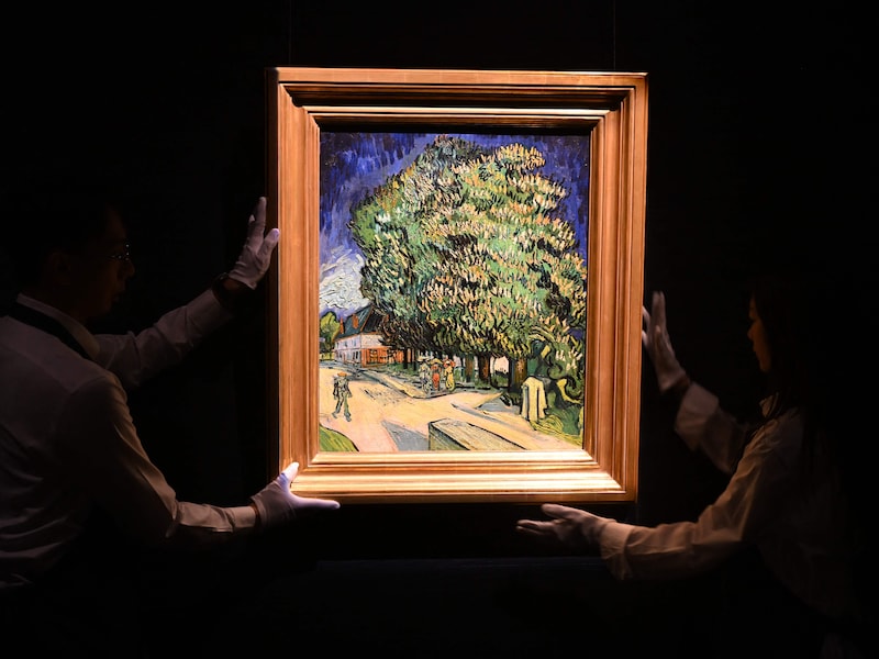 Medewerkers van Sotheby’s hangen het kunstwerk ‘Châtaigniers en fleurs’ van Vincent van Gogh op in Hongkong.