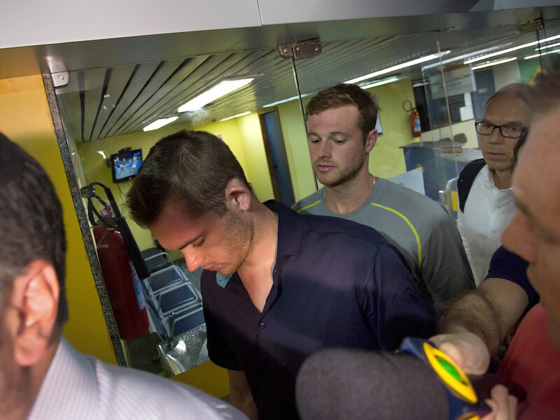 De olympische zwemmers Jack Conger (r) en Gunnar Bentz (l) werden door de Braziliaanse politie uit het vliegtuig gehaald dat op het punt stond om op te stijgen.