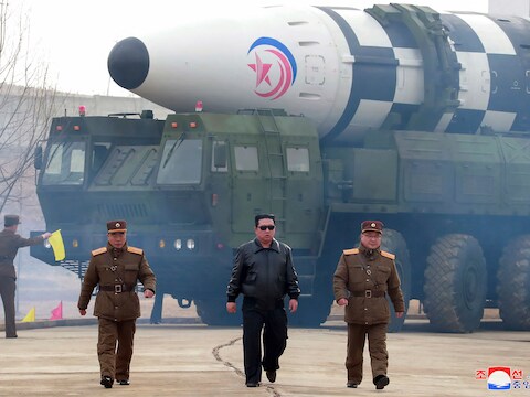 De Noord-Koreaanse leider Kim Jong-un met op de achtergrond wat volgens experts een Hwasong-17 zou zijn.