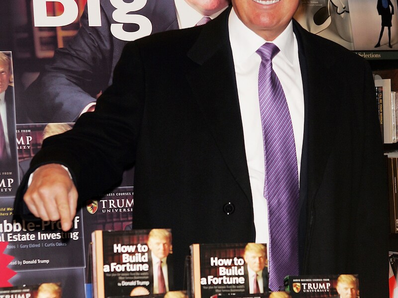 Donald Trump te midden van enkele van zijn cursusboeken.