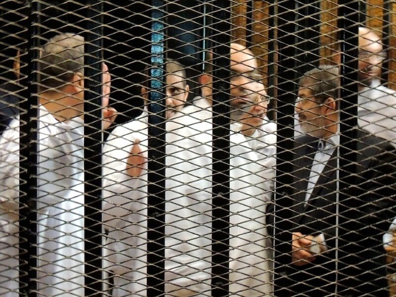 Mohammed Morsi (rechts) staat samen met andere leden van de Moslimbroederschap voor de rechtbank in Caïro.