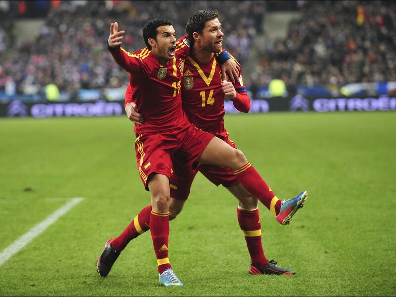 Pedro (links) viert zijn treffer met Xabi Alonso.