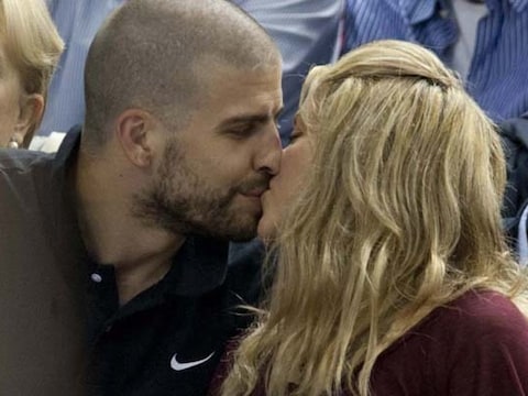 Gerard en Shakira zoenend bij een basketbalwedstrijd.