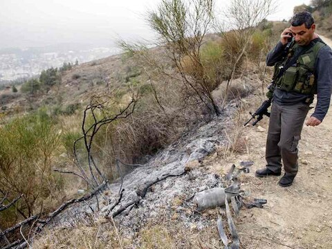 Een Israëlische veiligheidsfunctionaris staat bij de restanten van een van de ingeslagen raketten.