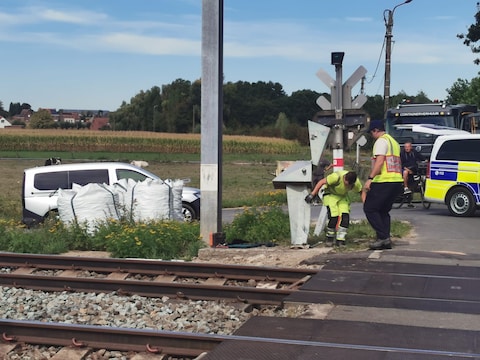 Technici van Infrabel bekijken de schade aan de installatie van de overweg in Pittem