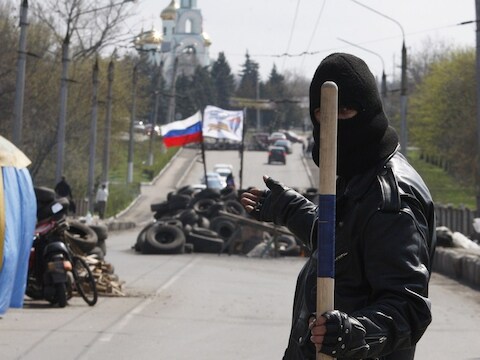 Een pro-Russische militant bewaakt een barricade bij de stad Slavjansk