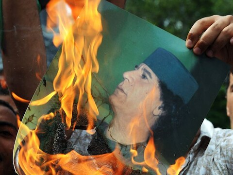 Een Libiër verbrandt een afbeelding van de leider Mouammar Kadhafi.