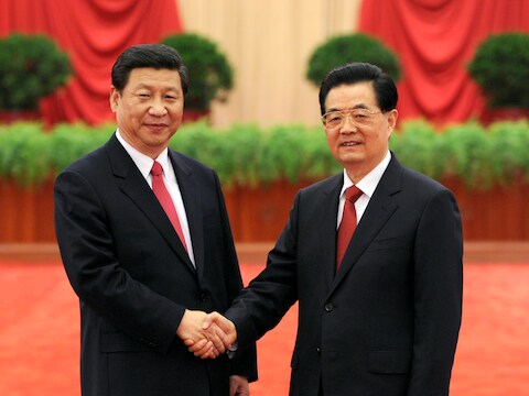 Hu Jintao (r.) schudt de hand van zijn opvolger Xi Jinping (l.).