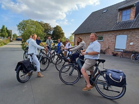 Fietsers op het hof van declerq in de middenstraat in Gits, waar er een grote verzameling van oude tractoren te bewonderen viel