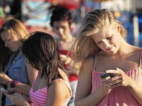 Het voorovergebogen hoofd tijdens het sms'en of surfen op je smartphone is nefast voor de nekwervels.