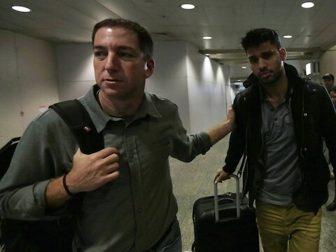 Guardian-verslaggever Glenn Greenwald (links) maandag bij het afhalen van zijn partner David Miranda op de luchthaven van Rio de Janeiro. Miranda werd zondag, onderweg vanuit Berlijn, op de Londense luchthaven Heathrow urenlang vastgehouden voor ondervraging.