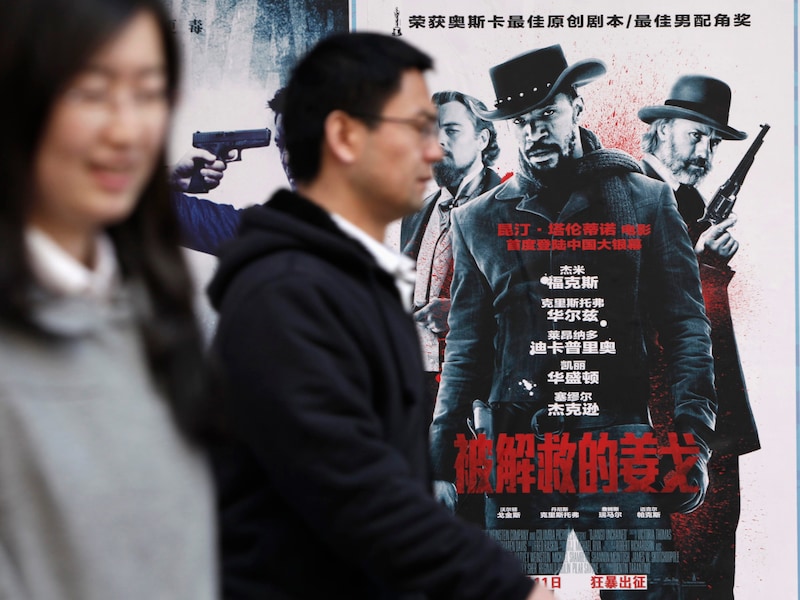 Mensen wandelen voorbij een poster van 'Django Unchained' aan een bioscoop in Peking.