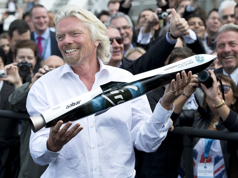 Richard Branson houdt een model vast van Launcher One voor Virgin Galactic.