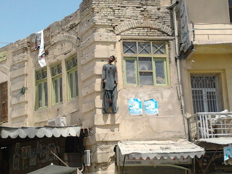Moordenaar Sardar Mohammad wordt opgehangen aan een gebouw in Kandahar