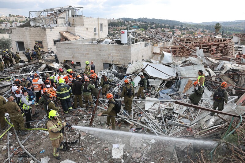 Reddingswerkers aan het werk tussen puin na een Iraanse raketaanval in Beit Shemesh.