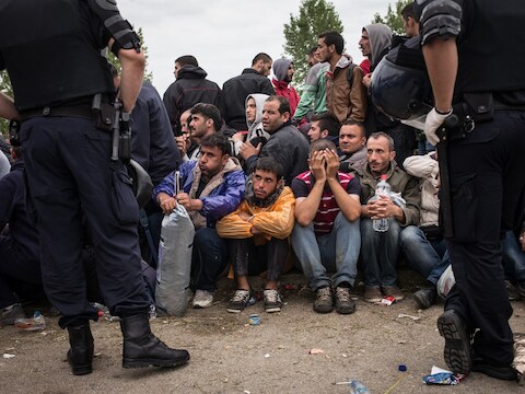Vluchtelingen wachten tot ze worden toegelaten tot een opvangkamp in Kroatië.