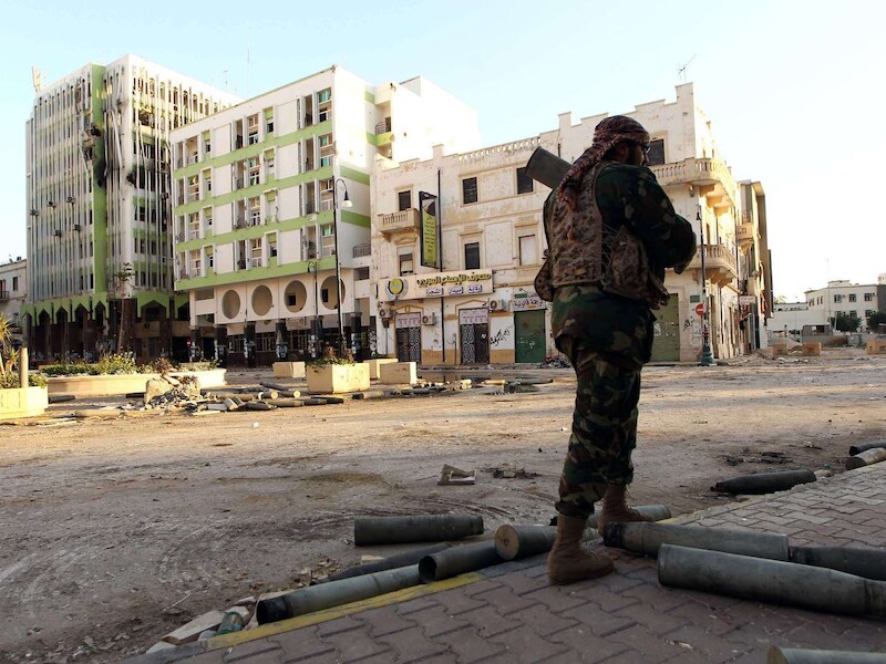 Een Libische militair patrouilleert door de straten van Benghazi.