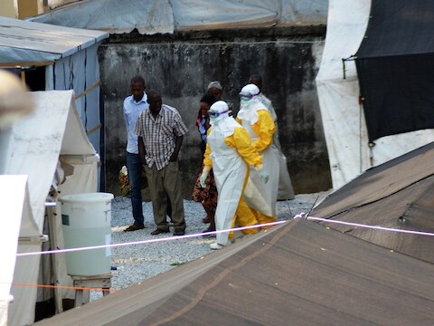 Medewerkers van een gezondheidsdienst in Sierra Leone dragen beschermende kleding op de plek waar het Donka-ziekenhuis patiënten met ebola heeft opgevangen.