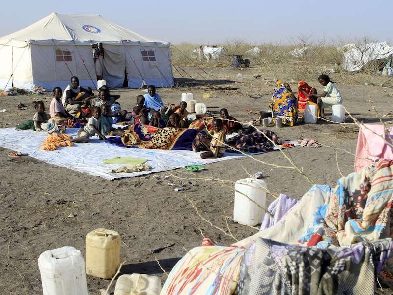 Zuid-Soedanese vluchtingen wachten op eten en drinken in een kamp van het Rode Kruis.