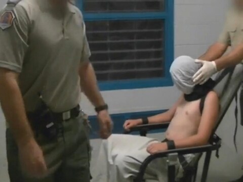 Een beeld uit de documentaire waarin te zien is hoe de jonge gevangenen worden mishandeld.
