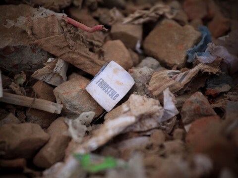 Een kledinglabel tussen het puin in Bangladesh.