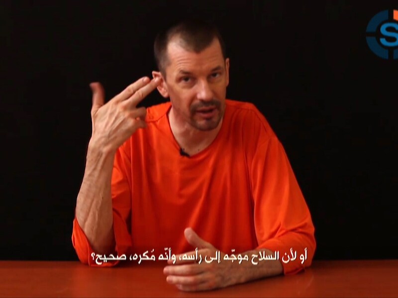 John Cantlie verscheen in drie eerdere videoboodschappen. Telkens is hij in het oranje gekleed.