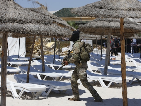 Een agent gisteren op het strand van het hotel in Sousse, vlak voor het bezoek van Britse, Franse, Duitse en Belgische vertegenwoordigers.