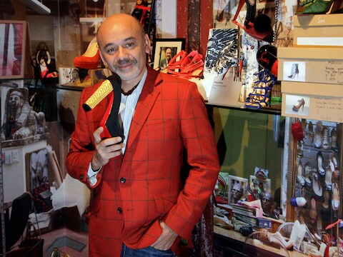 Christian Louboutin met één van zijn ontwerpen met rode zool