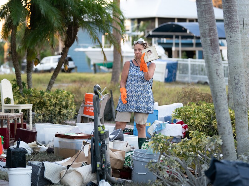Jane Cihon gaat in Naples, Florida door haar beschadigde spullen en familiefoto in de nasleep van orkaan Ian.
