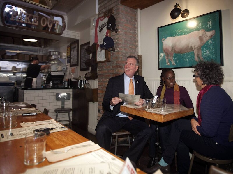 Burgemeester Bill de Blasio, zijn vrouw Chirlaine McCray en de gezondheidscommissaris van New York Mary Travis Bassett vanmiddag in The Meatball Shop.