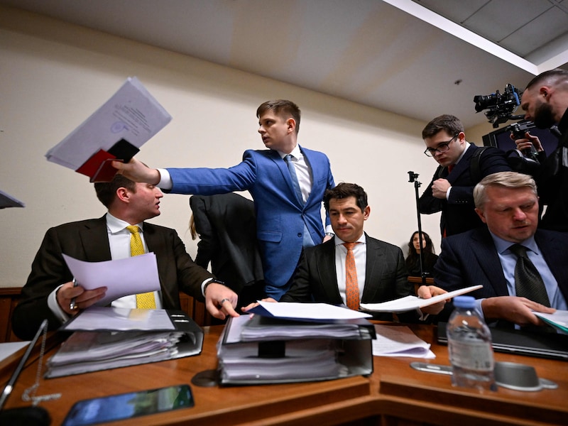 Advocaten van de Euroclear-groep maken zich klaar voor de zitting in de rechtbank in Moskou. Stapels papieren worden bovengehaald. 