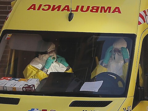Ambulanciers arriveren aan het appartement waar verpleegassistente Teresa Romero woont om het appartement te ontsmetten.