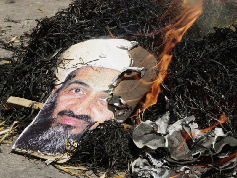 Een portret van Osama Bin Laden, brandend in de straten van New Dehli, India.